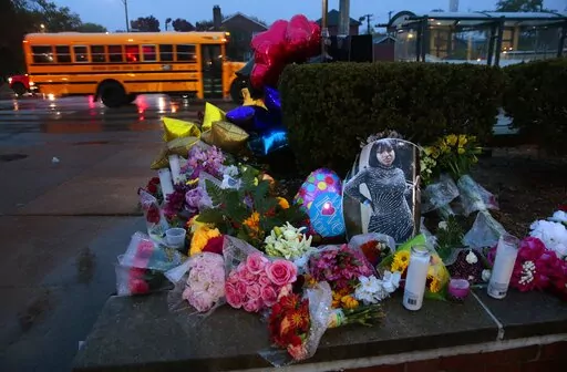 A photo of Alexandria Bell rests at the scene of a growing floral memorial to the victims of a school shooting at Central Visual & Performing Arts High School, Tuesday, Oct. 25, 2022, in St. Louis. Bell and teacher Jean Kuczka were killed, along with the gunman, in Monday's shooting. (Robert Cohen/St. Louis Post-Dispatch via AP)