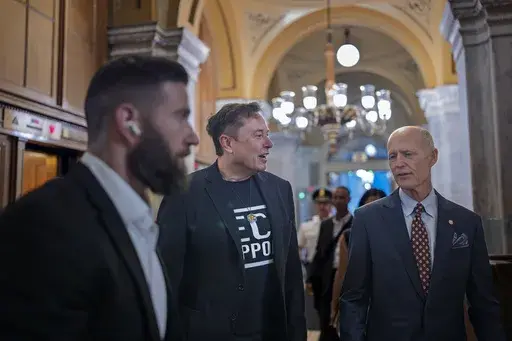 Elon Musk, center left, operating with a directive from President Donald Trump to slash government spending, walks with Sen. Rick Scott, R-Fla., right, as he arrives to meet with Republican senators, at the Capitol, in Washington, Wednesday, March 5, 2025. (AP Photo/J. Scott Applewhite)