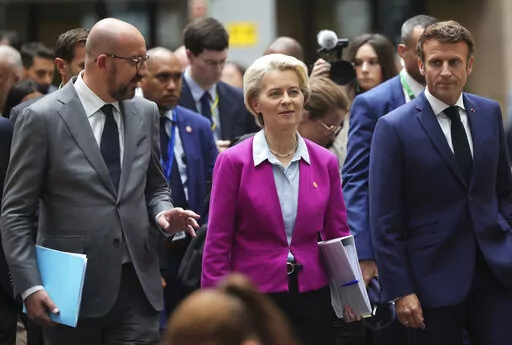 European Council President Charles Michel, left, European Commission President Ursula von der Leyen, center, and French President Emmanuel Macron, right, walk though the press room prior to a media conference at an EU summit in Brussels, Friday, June 24, 2022. EU leaders discussed economic topics at their summit in Brussels Friday amid inflation, high energy prices and a cost of living crisis. (AP Photo/Olivier Matthys)