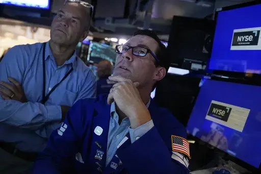 Specialist John McNierney, right, works with a colleague on the floor of the New York Stock Exchange, Aug. 7, 2024. (AP Photo/Richard Drew, File)