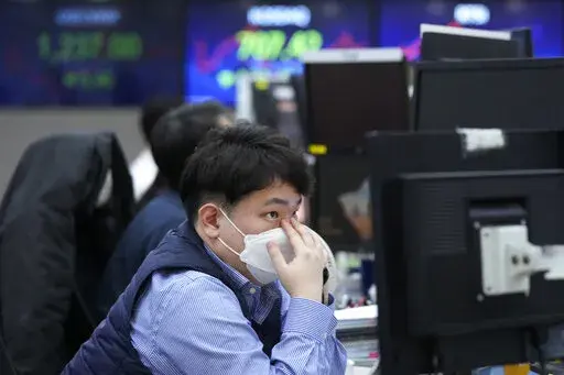 A currency trader watches monitors at the foreign exchange dealing room of the KEB Hana Bank headquarters in Seoul, South Korea, Thursday, Jan. 19, 2023. Asian shares were trading mixed Thursday, as investors grew cautious after Wall Street's biggest pullback of the year. (AP Photo/Ahn Young-joon)