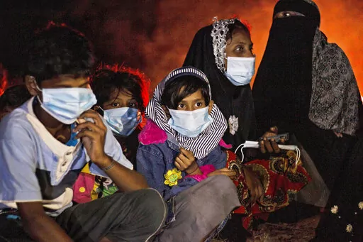 Ethnic Rohingya women and children sit by a fire on a beach after their boat was stranded on Idaman Island in East Aceh, Indonesia, late Friday, June 4, 2021, after leaving a refugee camp in Bangladesh, officials said. U.S. officials say the Biden administration intends to declare that Myanmar's years-long repression of the Rohingya Muslim population is a “genocide.” Two officials say Secretary of State Antony Blinken plans to announce the long-anticipated designation on Monday, March 21, 20