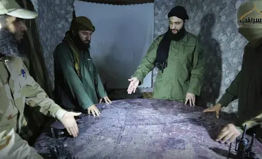 This undated photo released by a militant group in 2016, shows Abu Mohammed al-Golani, the leader of Syria's al-Qaida affiliate, second from right, discussing battlefield details with commanders in Aleppo, Syria. (Militant UGC via AP, File)