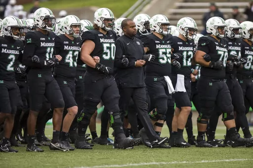 Marshall players and coaches take the field against UAB in an NCAA college football game on Saturday, Nov. 13, 2021, at Joan C. Edwards Stadium in Huntington W.Va. On Tuesday, March 29, 2022, Conference USA announced in a joint statement with Marshall, Old Dominion and Southern Miss that it has reached a resolution with the three schools to expedite their early move to the Sun Belt. (Sholten Singer/The Herald-Dispatch via AP, File)