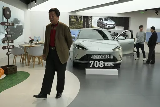 Visitors look at the Arcfox a-S, an all electric car from Chinese automaker BAIC which claims to have a 708km range on a single charge, at a show room in Beijing, Thursday, April 13, 2023. Global and Chinese automakers plan to unveil more than a dozen new electric SUVs, sedans and muscle cars this week at the Shanghai auto show, their first full-scale sales event in four years in a market that has become a workshop for developing electrics, self-driving cars and other technology. (AP Photo/Ng Ha