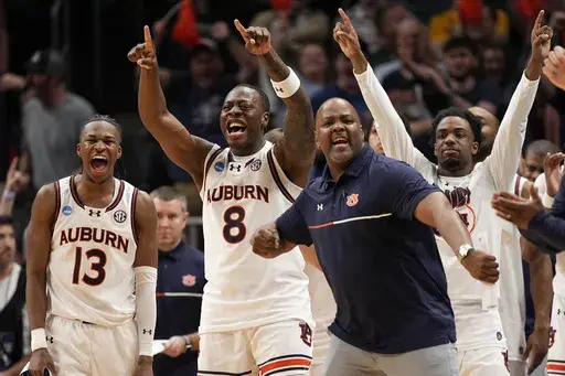 The Auburn bench celebrates during the second half in the Sweet 16 of the NCAA college basketball tournament against Michigan, Saturday, March 29, 2025, in Atlanta. (AP Photo/George Walker IV)