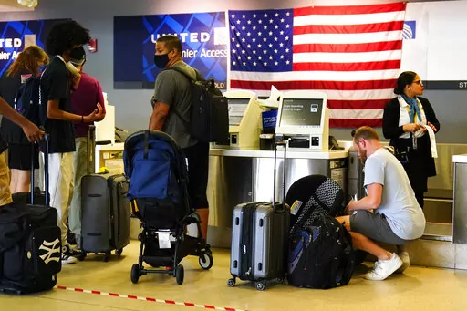 Travelers check in at the Philadelphia International Airport ahead of the Independence Day holiday weekend in Philadelphia, Friday, July 1, 2022.  The July Fourth holiday weekend is off to a booming start with airport crowds crushing the numbers seen in 2019, before the pandemic. (AP Photo/Matt Rourke)