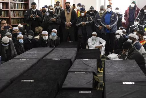 Caskets sit on the floor during the funeral service for victims from the apartment building which suffered the city's deadliest fire in three decades, at the Islamic Cultural Center for the Bronx on Sunday, Jan. 16, 2022, in New York. (AP Photo/Yuki Iwamura)