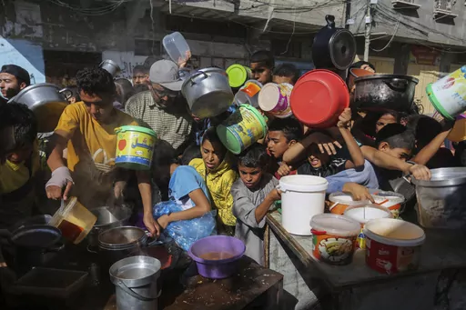 Palestinians crowd together as they wait for food distribution in Rafah, southern Gaza Strip, Nov. 8, 2023. Catastrophic hunger is so dire in two world hotspots that famine is imminent in northern Gaza and approaching in Haiti, with hundreds of thousands of people in both places struggling to avoid starvation, according to international food security experts and aid groups. (AP Photo/Hatem Ali, File)