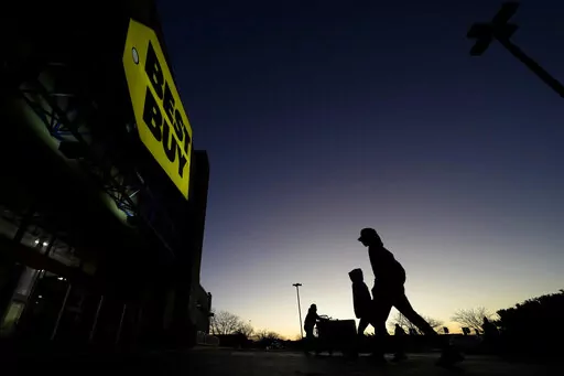 Shoppers are silhouetted against the sky as they arrives for a sale at a Best Buy store Friday, Nov. 25, 2022, in Overland Park, Kan. On Friday the Commerce Department issues its November report on consumer spending. The report contains a measure of inflation that is closely watched by the Federal Reserve, which has aggressively tried to corral inflation this year by raising its key lending rate seven times. (AP Photo/Charlie Riedel, File)