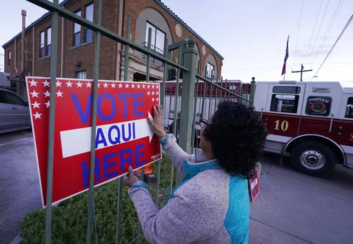 Election worker Ramona Ortiz places a sign outside a polling station at Fire Station 3 on E. Rio Grande Ave in El Paso, Texas, just before polls open on Nov. 8, 2022. Next year is shaping up to be another busy for state legislatures seeking to change voting laws. (AP Photo/LM Otero, File)