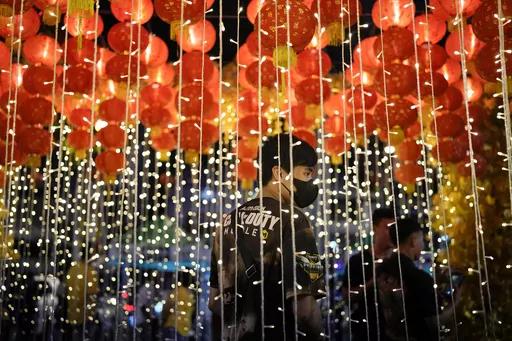 A man stands under lanterns during an event for the 430th anniversary of Manila's Chinatown, said to be the oldest in the world, at the capital's Binondo district, Philippines on Thursday, Feb. 1, 2024. Crowds are flocking to Manila's Chinatown to usher in the Year of the Wood Dragon and experience lively traditional dances on lantern-lit streets with food, lucky charms and prayers for good fortune. (AP Photo/Aaron Favila)