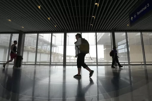 Carol Giuliani, who is a member of the Dementia-Friendly Airports Working group and works as a travel companion for seniors with dementia, walks through Terminal 3 at Phoenix Sky Harbor International Airport after bringing a client from Minnesota Wednesday, Aug. 23, 2023, in Phoenix. “Ninety percent of the time it’s a family member that hires me,” said Giuliani, while seated at Phoenix Sky Harbor after escorting an elderly man on a flight. “The one I did today, (the wife) was like ‘tha