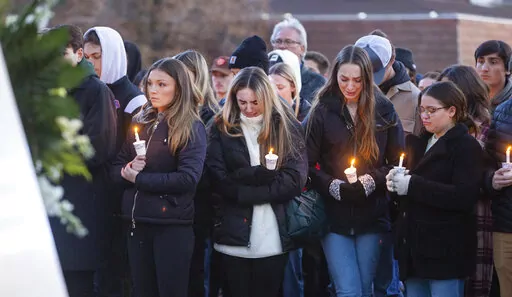 Boise State University students, along with people who knew the four University of Idaho students who were found killed in Moscow, Idaho, days earlier, pay their respects at a vigil held in front of a statue on the Boise State campus, Thursday, Nov. 17, 2022, in Boise, Idaho. Autopsies performed on the four students who were found dead inside a rental house near campus showed that all four were stabbed to death, the Latah County coroner said. (Sarah A. Miller/Idaho Statesman via AP)