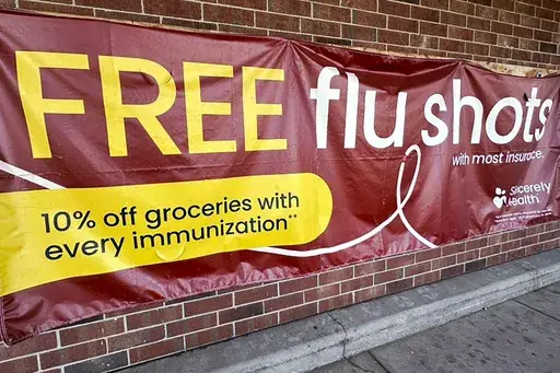 A sign for flu vaccination is displayed outside of a grocery store in Glenview, Ill., Thursday, Feb. 15, 2024. (AP Photo/Nam Y. Huh, File)