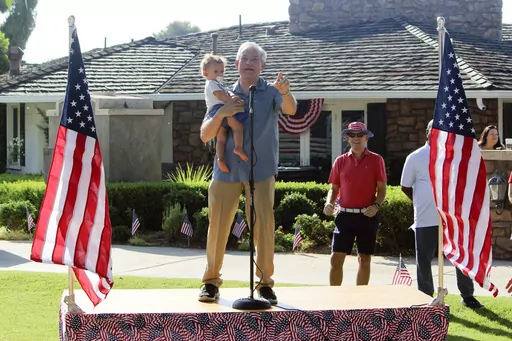 Rep. David Schweikert, R-Ariz., holding his one-year-old son Matthew, speaks at an Independence Day parade on Tuesday, July 4, 2023 in Phoenix. Schweikert, who won his last election by just 3,200 votes, is now among the top 2024 targets for Democrats, who sense better-than-expected odds of retaking the House majority they lost last year. (AP Photo/Jonathan J. Cooper)