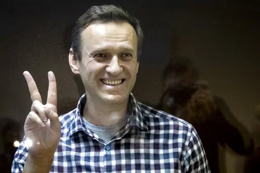 FILE -- Russian opposition leader Alexei Navalny gestures as he stands behind a glass panel of a cage in the Babuskinsky District Court in Moscow, Russia, Saturday, Feb. 20, 2021. On the second anniversary of the poison attack on Alexei Navalny, Germany and the United States have recalled the fate of Kremlin critic Alexei Navalny who is imprisoned in Russia. German Chancellor Olaf Scholz praised the Russian opposition politician’s courage in a video message Saturday. (AP Photo/Alexander Zemlia