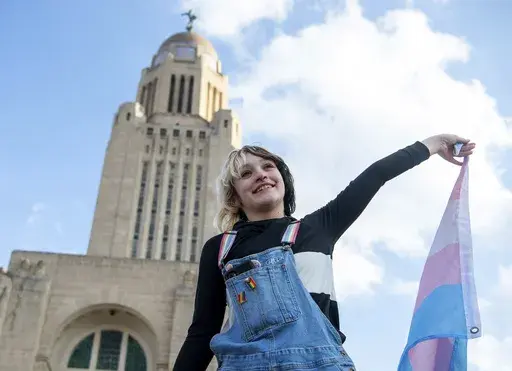 Gene Sorensen holds up a transgender flag in front of the Nebraska state Capitol during a Transgender Day of Visibility rally, March 31, 2023, in Lincoln, Neb. (Larry Robinson/Lincoln Journal Star via AP, file)