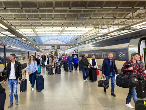 Travelers at St. Pancras International train station board the high speed Eurostar train to Paris, in London, Saturday, May 21, 2022. The World Economic Forum is encouraging European attendees to come to its exclusive gathering in the Swiss Alps by train. Its part of efforts to burnish the sustainability credentials for an event in Davos that conjures up up images of government leaders, billionaire elites and corporate titans jetting in on carbon-spewing private planes. (AP Photo/Kelvin Chan)