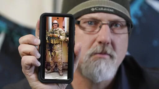 Matthew Butler, who spent 27 years in the Army, holds a 2014 photograph of himself during his last deployment in Kabul Afghanistan, on Wednesday, March 30, 2022, in Sandy, Utah. Butler is now one of the military veterans in several U.S. states who are helping convince conservative lawmakers to take cautious steps toward allowing the therapeutic use of hallucinogenic mushrooms and other psychedelic drugs. The therapeutic used of so-called magic mushrooms and other psychedelic drugs is making inro