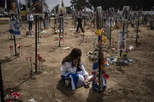 A woman grieves at a memorial for those killed and abducted during the Oct. 7, 2023, cross-border attack by Hamas militants, near the kibbutz Reim, southern Israel, May 13, 2024. (AP Photo/Leo Correa, File)