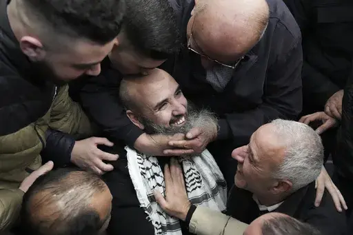Palestinian prisoner Waddeh Bazrah, 43, is greeted after being released from Israeli prison following a ceasefire agreement between Israel and Hamas, in the West Bank city of Ramallah, Saturday, Feb. 15, 2025. (AP Photo/Mahmoud Illean)