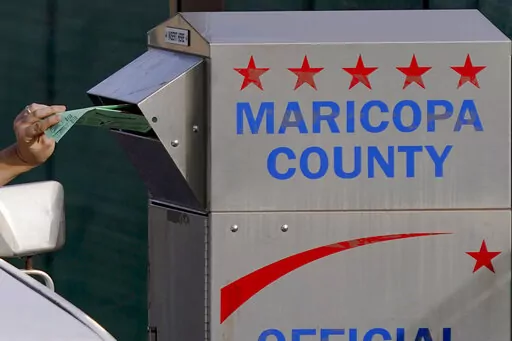 A voter casts their ballot at a secure ballot drop box at the Maricopa County Tabulation and Election Center in Phoenix, Tuesday, Nov. 1, 2022.  On Friday, Nov. 11, The Associated Press reported on stories circulating online incorrectly claiming when ballots were rejected by tabulators at some voting locations across Maricopa County on Election Day, an alternate solution for voters to drop ballots in a secure drop box onsite resulted in the ballots getting shredded, thrown in the trash, or marke