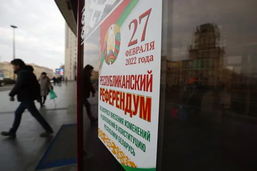 People walk past a poster which reads "Referendum on constitutional amendments" in Minsk, Belarus, Wednesday, Feb. 16, 2022. Belarusians vote at a referendum on constitutional amendments that could allow country's strongman Alexander Lukashenko to further cement his grip on power until 2035. (AP Photo/Alexander Zemlianichenko Jr)