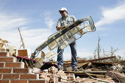 Charlie Weissinger carefully removes a stained glass window frame as he searches for his family's stained glass window in the rubble left from a March 24 tornado, that hit The Chapel of The Cross Episcopal Church in Rolling Fork, Miss., on March 29, 2023. The Weissinger family roots run deep in the 99-year old church and largely farming community and he expects his family will join members in rebuilding the church and repairing the family home which was damaged by the killer tornado. (AP Photo/R