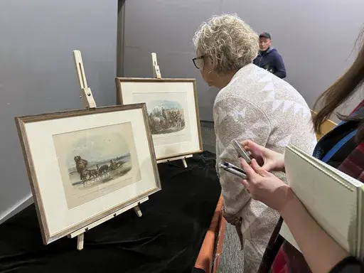 Two women view aquatints by artist Karl Bodmer on Wednesday, Dec. 4, 2024, at the North Dakota Heritage Center and State Museum in Bismarck, N.D. Bodmer created numerous artworks of Native Americans and their culture along the Upper Missouri River during an 1830s expedition. (AP Photo/Jack Dura)