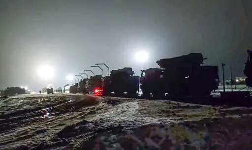 In this photo taken from video provided by the Russian Defense Ministry Press Service on Saturday, Jan. 29, 2022, Russian military vehicles prepares to drive off a railway platforms after arrival in Belarus. In a move that further beefs up forces near Ukraine, Russia has sent an unspecified number of troops from the country's far east to its ally Belarus, which shares a border with Ukraine, for major war games next month. (Russian Defense Ministry Press Service via AP)
