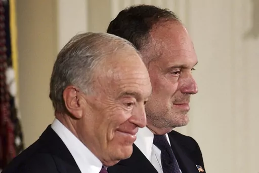 Leonard Lauder, left, and Ronald Lauder, sons of the late cosmetics mogul Estée Lauder, stand next to U.S. President George W. Bush, not pictured, as they receive the Presidential Medal of Freedom on her behalf, which was awarded posthumously to her during a ceremony at the White House in Washington, June 23, 2004. The sons of cosmetics giant Estée Lauder, along with her four grandchildren, pledged $200 million Tuesday, April 4, 2023, to the Alzheimer’s Drug Discovery Foundation, a nonprofit