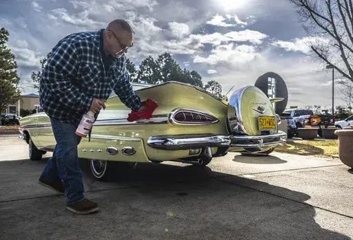 Joe Romero of Albuquerque shines his original 1959 Chevy Impala outside the State Capitol in Santa Fe, N.M. on Low Rider day, Tuesday, Feb. 11, 2025. (AP Photo/Roberto E. Rosales)