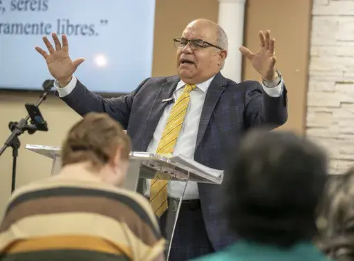Rev. Esteban Rodriguez, who leads Centro Cristiano El Pan de Vida, prays for congregants during a church service in Kissimmee, Fla. Sunday, Feb. 2, 2025. (AP Photo/Alan Youngblood)