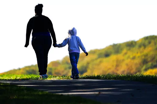 A woman and child walk on a trail at Valley Forge National Historical Park in Valley Forge, Pa., Nov. 1, 2021. Senate Democrats and Republicans each want to flash election-year signals that they’re helping families struggling with rising costs and the two-year-old pandemic. But the parties differ over how to do that. (AP Photo/Matt Rourke, File)