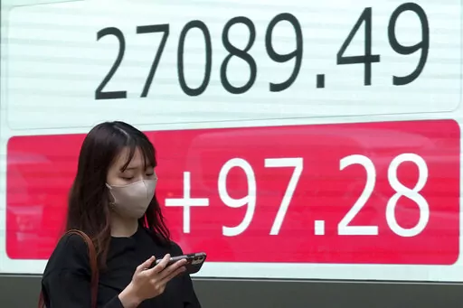 A person walks in front of an electronic stock board showing Japan's Nikkei 225 index at a securities firm Wednesday, Oct. 5, 2022, in Tokyo. Hong Kong’s share benchmark soared more than 5% on Wednesday as Asian shares tracked gains on Wall Street. (AP Photo/Eugene Hoshiko)