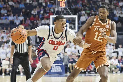 Mississippi guard Matthew Murrell (11) is fouled by Texas guard Tramon Mark (12) during the first half of an NCAA college basketball game in Oxford, Miss., Wednesday, Jan. 29, 2025. (AP Photo/Bruce Newman)