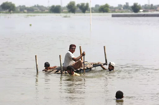 People use cot to salvage belongings from their nearby flooded home caused by heavy rain in Jaffarabad, a district of Pakistan's southwestern Baluchistan province, Saturday, Sep. 3, 2022. The homeless people affected by monsoon rains triggered devastating floods in Pakistan get enhancing international attention amid growing numbers of fatalities and homeless families across the country as the federal planning minister appealed the international community for immense humanitarian response for 33 
