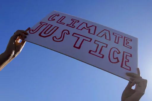 A demonstrator holds a sign reading "climate justice" at a Fridays for Future protest calling for money for climate action at the COP27 U.N. Climate Summit, Nov. 11, 2022, in Sharm el-Sheikh, Egypt. As the U.N. climate talks in Egypt near the half-way point, negotiators are working hard to draft deals on a wide range of issues they’ll put to ministers next week in the hope of getting a substantial result by the end. (AP Photo/Peter Dejong, File)