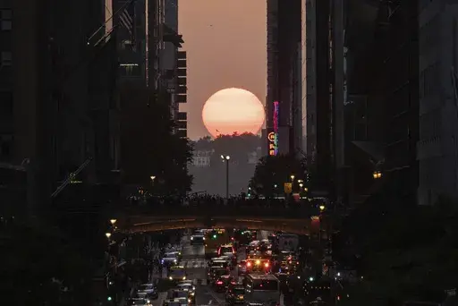 The sun sets between buildings along 42nd Street in New York during a phenomenon known as "Manhattanhenge," May 30, 2023. Twice per year, New Yorkers and visitors are treated to a phenomenon known as Manhattanhenge, when the setting sun aligns with the Manhattan street grid and sinks below the horizon framed in a canyon of skyscrapers. Manhattanhenge happens for the first time this year on Tuesday, May 28, at 8:13 p.m. and Wednesday, May 29, at 8:12 p.m. (AP Photo/Yuki Iwamura, File)