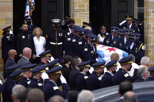 FILE - Elizabeth French, in white, and her son Andrew, left, follow the casket of her daughter, Chicago police officer Ella French, after a funeral service at the St. Rita of Cascia Shrine Chapel Thursday, Aug. 19, 2021, in Chicago. French was killed and her partner was seriously wounded during an Aug. 7 traffic stop on the city's South Side. The year 2021 ended as one of the deadliest on record in recent years in Chicago, according to statistics released by the city's police department on Satur