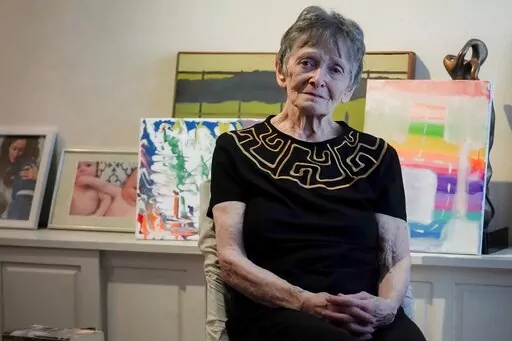 Ellen Ensig-Brodsky, 89, a LGBTQ rights activist, pose in her home, Wednesday, June 22, 2022, in New York. Even with ailing knees, Ensig-Brodsky said she plans to be on the Pride Parade route on Sunday. "The parade is the display, publicly, of my identity." (AP Photo/Bebeto Matthews)