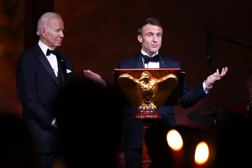 President Joe Biden listens as French President Emmanuel Macron speaks before a toast during a State Dinner on the South Lawn of the White House in Washington, Thursday, Dec. 1, 2022. (AP Photo/Andrew Harnik)
