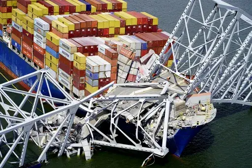 In this aerial image released by the Maryland National Guard, the cargo ship Dali is stuck under part of the structure of the Francis Scott Key Bridge after the ship hit the bridge, March 26, 2024, in Baltimore. (Maryland National Guard via AP, File)