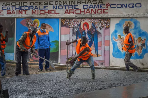 Construction workers lay concrete outside the Cathedral Notre Dame du Congo in Kinshasa, Democratic Republic of the Congo Saturday Jan. 28, 2023. Pope Francis will be in Congo and South Sudan for a six-day trip starting Jan, 31, hoping to bring comfort and encouragement to two countries that have been riven by poverty, conflicts and what he calls a "colonialist mentality" that has exploited Africa for centuries. (AP Photo/Jerome Delay)