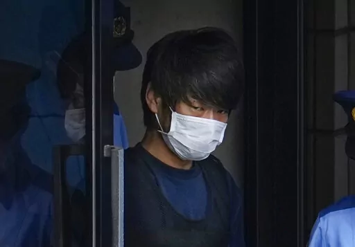 Tetsuya Yamagami, the alleged assassin of Japan's former Prime Minister Shinzo Abe, exits a police station in Nara, western Japan, on July 10, 2022, on his way to local prosecutors' office. Yamagami is expected to face murder charges Friday, Jan. 13, 2023, in Japan's highest profile case in recent years. (Nobuki Ito/Kyodo News via AP, File)