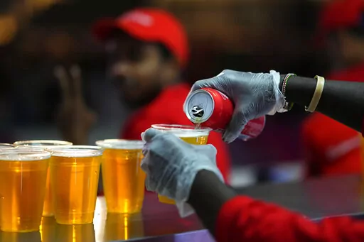 Staff member pours a beer at a fan zone ahead of the FIFA World Cup, in Doha, Qatar Saturday, Nov. 19, 2022. The last-minute decision to ban the sale of beer at World Cup stadiums in Qatar is the latest example of some the tensions that have played out ahead of the tournament. Qatari officials have for long said they were eager to welcome everybody but that visitors should also respect their culture and traditions. (AP Photo/Petr Josek)