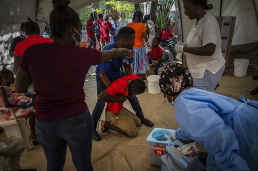 A youth suffering from cholera symptoms is helped upon arrival at a clinic run by Doctors Without Borders in Port-au-Prince, Haiti, Thursday, Oct. 27, 2022. For the first time in three years, people in Haiti have been dying of cholera, raising concerns about a potentially fast-spreading scenario and reviving memories of an epidemic that killed nearly 10,000 people a decade ago. (AP Photo/Ramon Espinosa)
