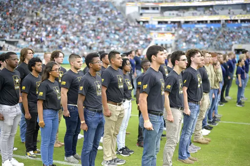 Military recruits are sworn in during halftime on Salute to Service military appreciation day at an NFL football game between the Jacksonville Jaguars and the Las Vegas Raiders, Nov. 6, 2022, in Jacksonville, Fla. The Army is trying to recover from its worst recruiting year in decades, and officials say those recruiting woes are the result of traditional hurdles. Young people don’t want to die or get injured, they don't want to deal with the stress of Army life and they don't want to put their