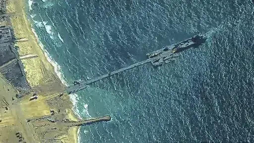 The image provided by U.S, Central Command, shows U.S. Army soldiers assigned to the 7th Transportation Brigade (Expeditionary), U.S. Navy sailors assigned to Amphibious Construction Battalion 1, and Israel Defense Forces placing the Trident Pier on the coast of Gaza Strip on Thursday, May 16, 2024. The temporary pier is part of the Joint Logistics Over-the-Shore capability. The U.S. military finished installing the floating pier on Thursday, with officials poised to begin ferrying badly needed 